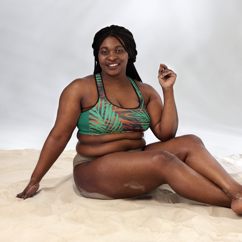Padded sports bra in teal green with orange leaf pattern, scoop neckline, racerback