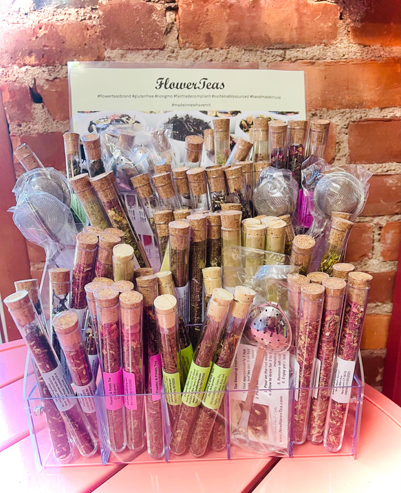 Rack display of clear tea test tubes with cork tops and colorful labeled wrappers