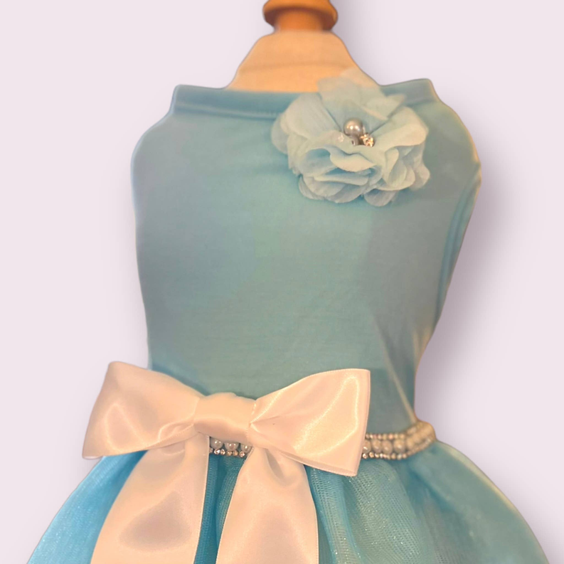 Teal sleeveless dress with rosette flower at shoulder, cream bow, and beaded waist