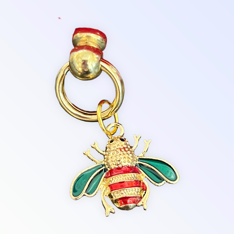 Red velvet pet collar with gold O-ring and clasp, featuring a bee pendant with green wings.