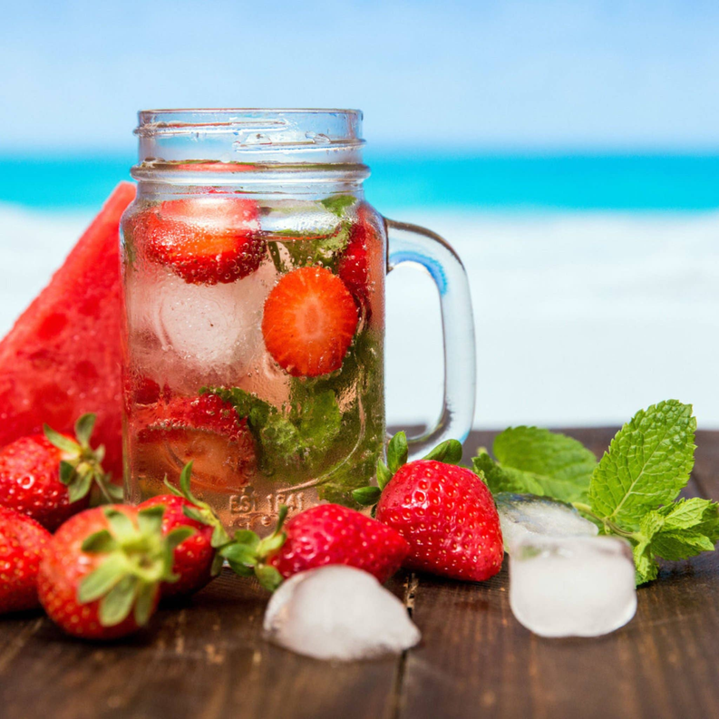 Wild strawberry iced tea in glass jar with strawberries and mint