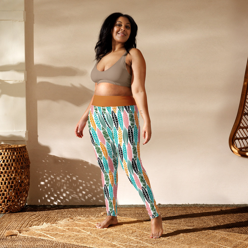 Yoga leggings, side view, multicolored leaf pattern on white with tan waistband