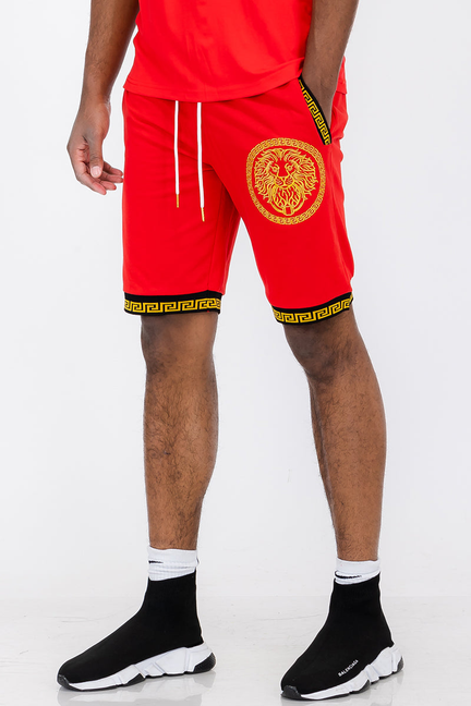 Red lion head drawstring shorts with gold emblem and Greek key trim