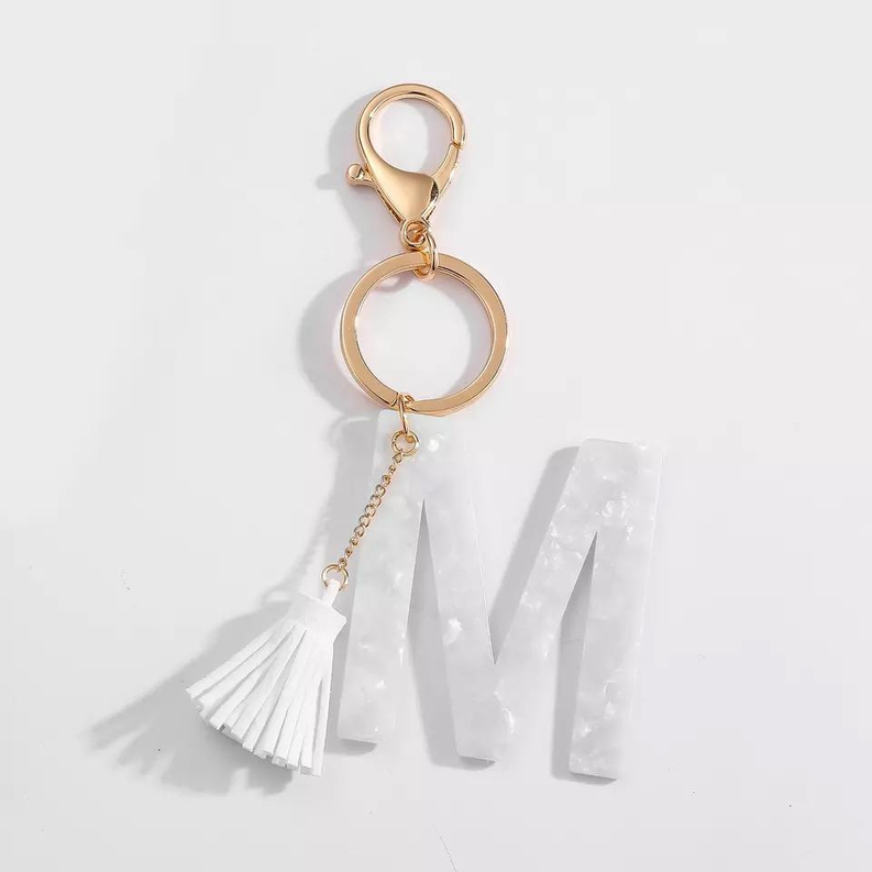 White tasseled initial M key chain with gold ring and hanging letter charm