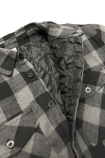 Quilted plaid flannel shirt close-up: button placket with black-and-grey check, quilted lining