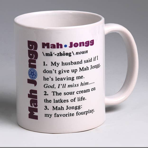 White ceramic Mah Jongg mug, angled view, purple quote and vertical wordmark