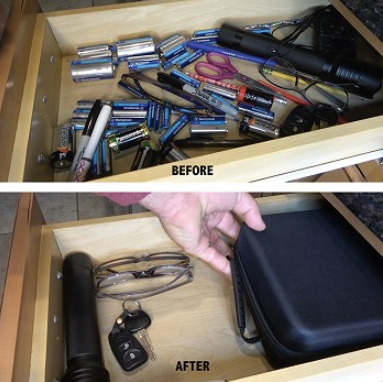 Dark navy zippered battery storage case held open in drawer with key fob and cables
