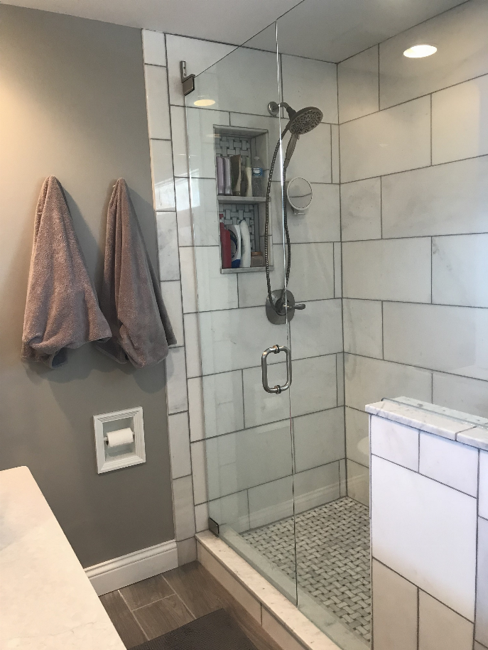 Recessed solid wood toilet paper holder installed in a tile wall niche