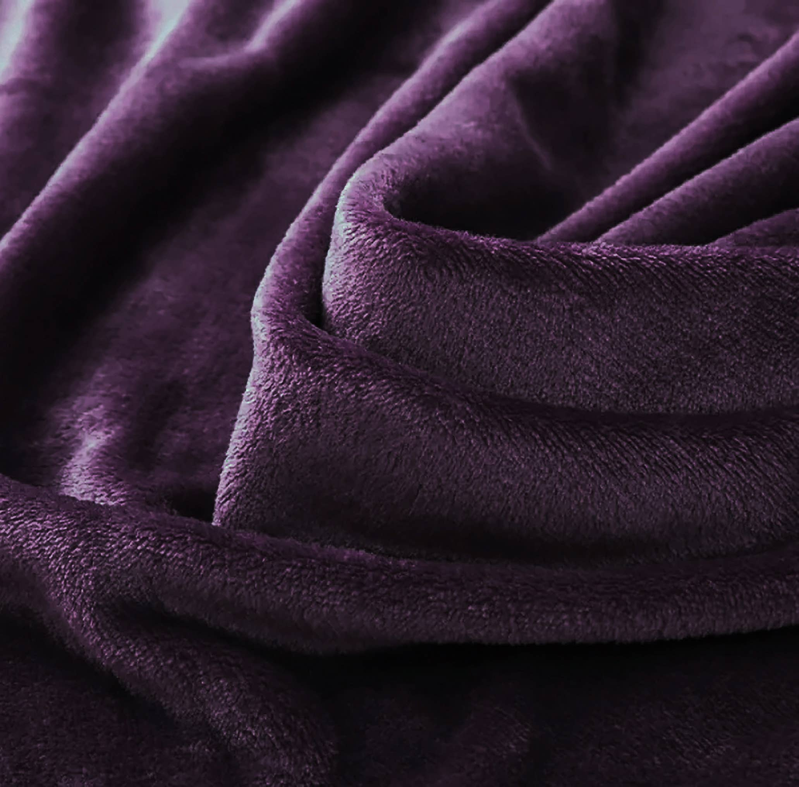 Purple plush blanket fabric close-up with thick velvety pile
