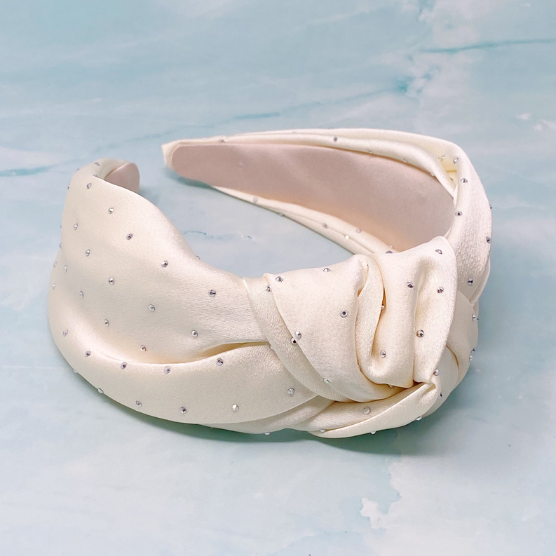 Satin knotted headband in pale pink with small rhinestone dot accents