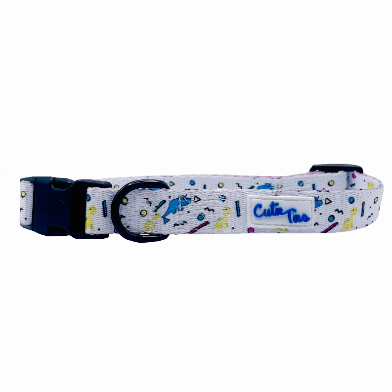 Dog collar with white dinosaur confetti pattern, black buckle hardware and metal D-ring