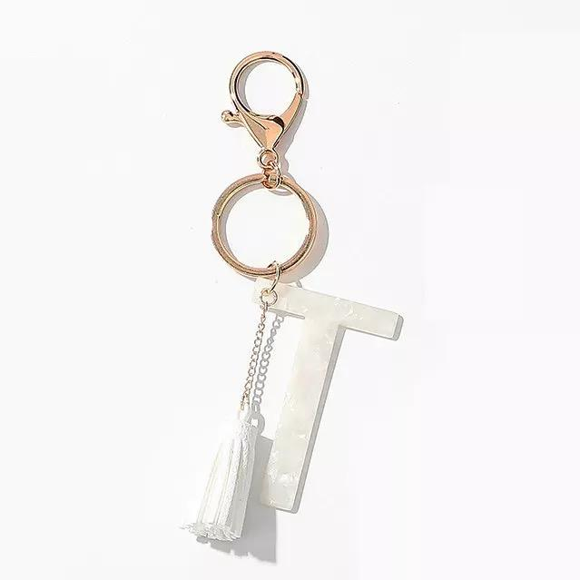 White tassel initial key chain with metal key rings and T letter tag