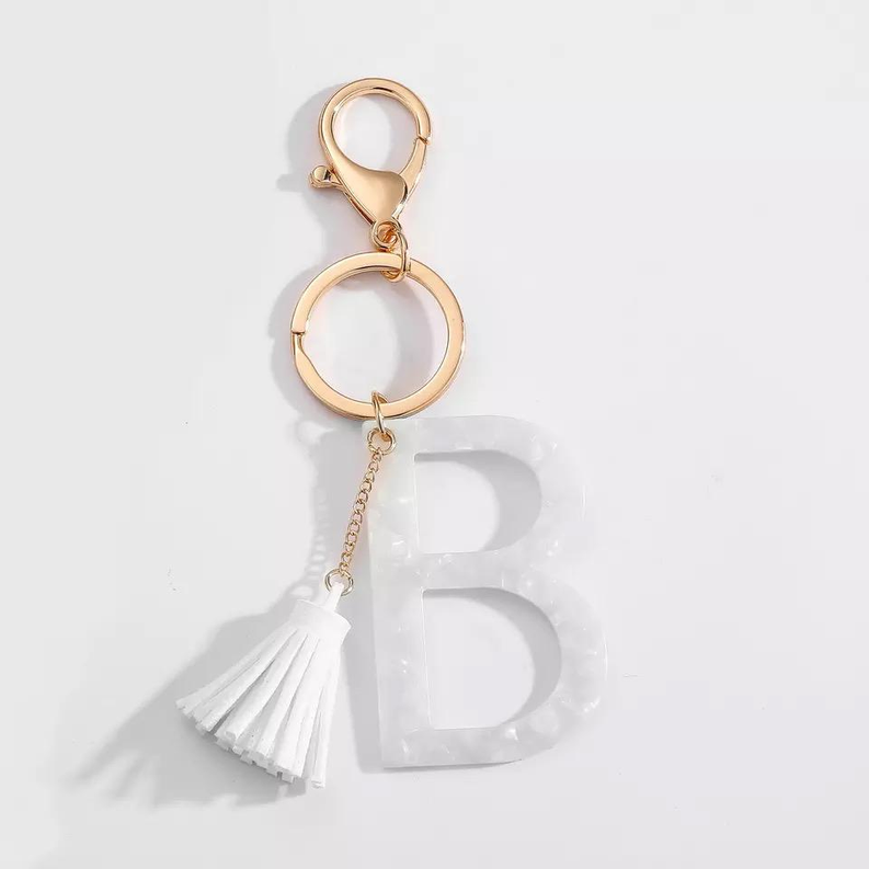 White initial B key chain with gold ring hardware and white tassel charm