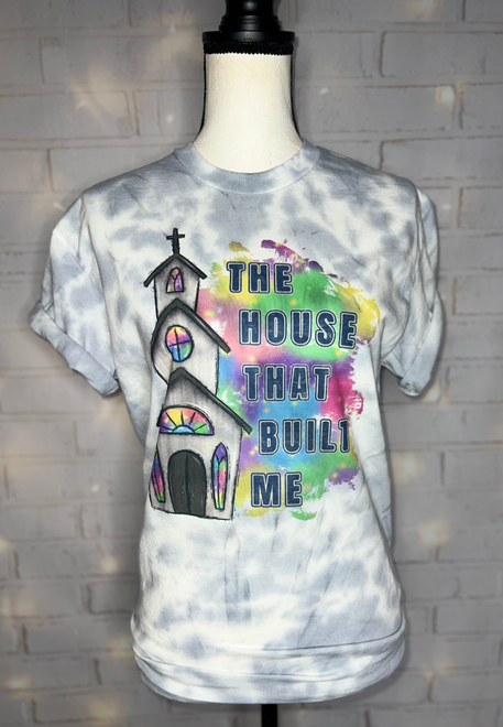 Light blue tie-dye graphic tee with multicolor text and church/cross print