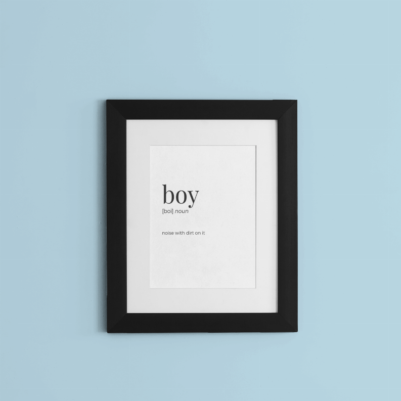 Framed wall art print with 'boy' text centered on white paper, black frame