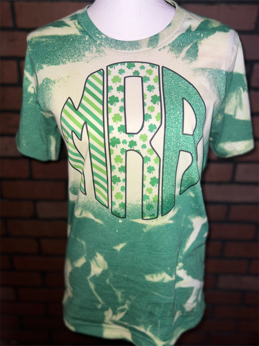Green and cream bleached graphic monogram tee with shamrock and striped letter
