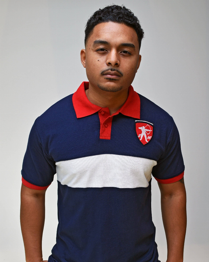 Navy polo with red collar, white mid-chest stripe, crest badge on left chest
