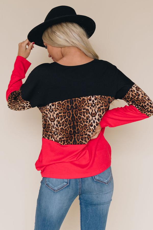 Back view: black leopard-print top with red sleeves and curved hem