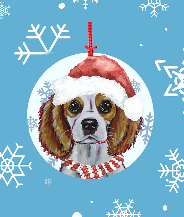 Round Christmas tree ornament with a Cavalier dog wearing a red Santa hat and scarf