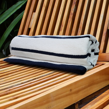 Striped pool towel set, folded white towel with navy horizontal stripes