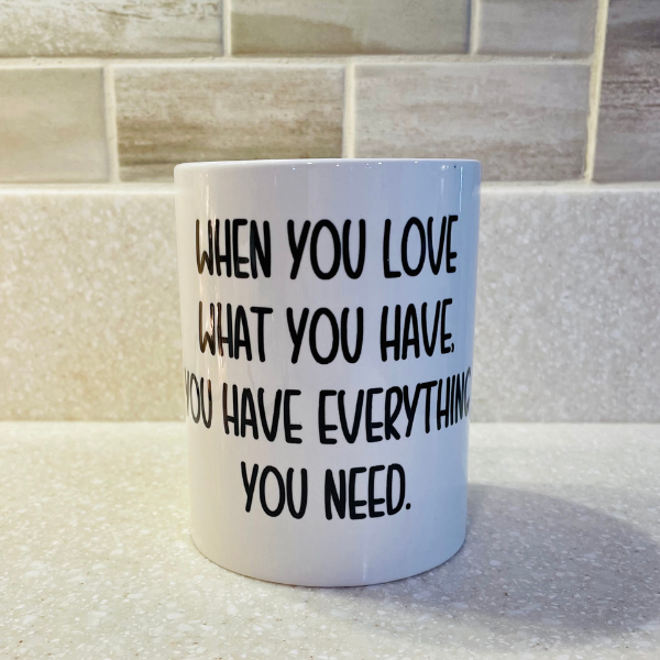 15oz light blue coffee mug with quote: “When you love what you have… you need.”