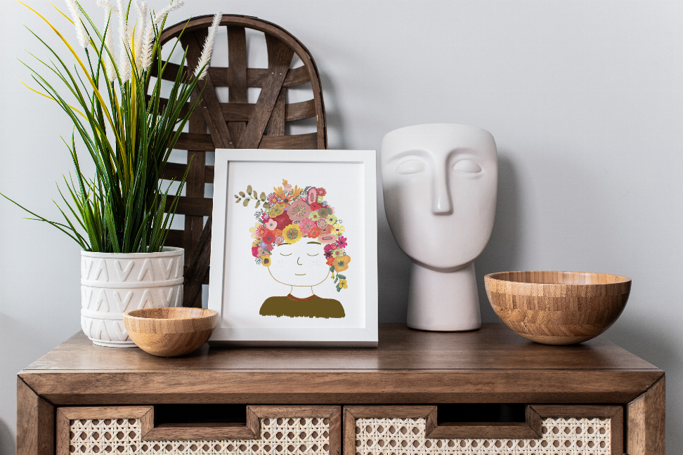 Framed floral lady portrait print with flower crown, displayed on a wooden cabinet