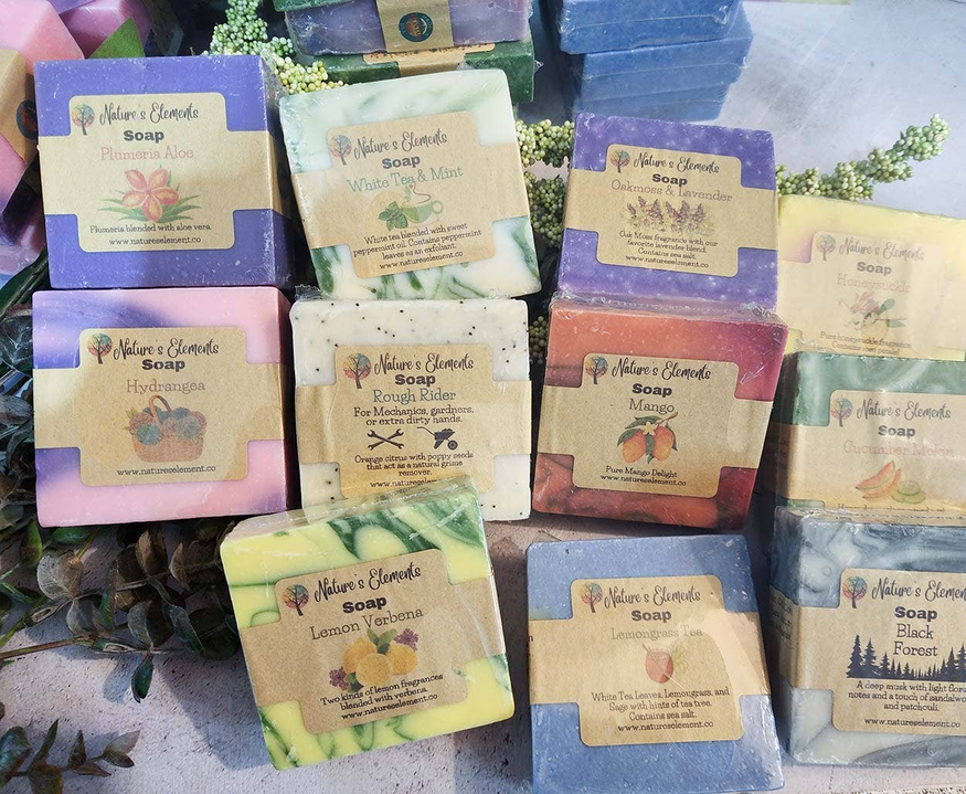 Assorted handcrafted soap bars in multiple colors, each with beige label