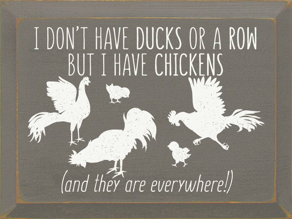 Chalkboard-style sign with white chicken quote and rooster silhouettes