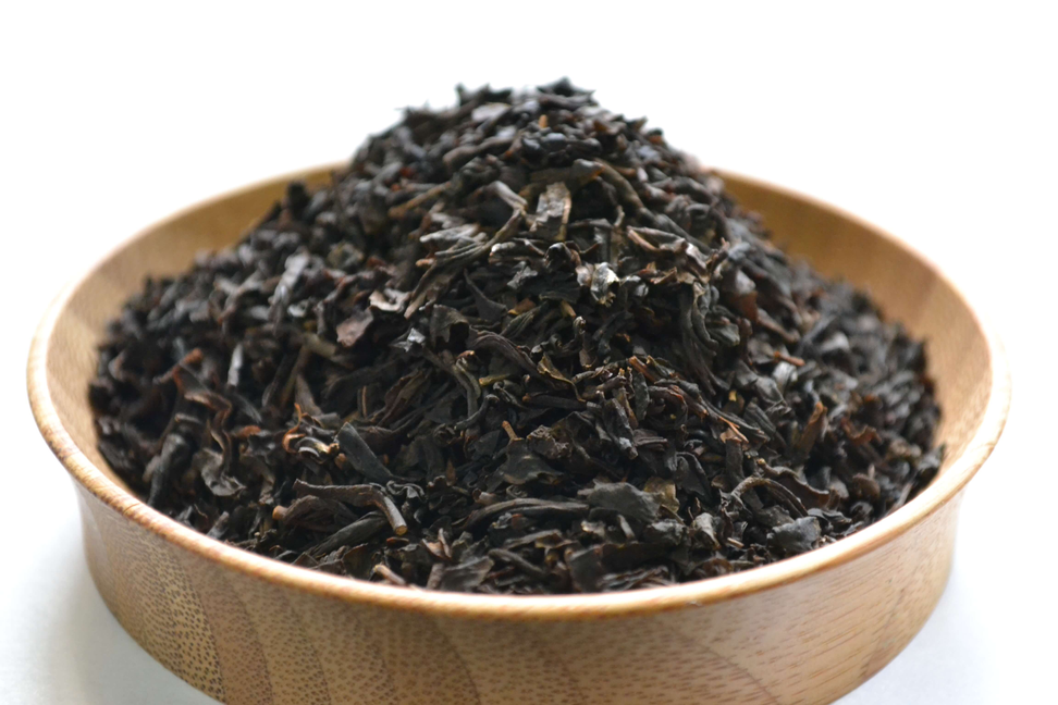 Vanilla flavored tea leaves piled in a wooden bowl