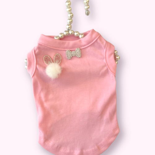 Pink sleeveless dog shirt with sequin bunny ears and bow; fuzzy white pom-pom