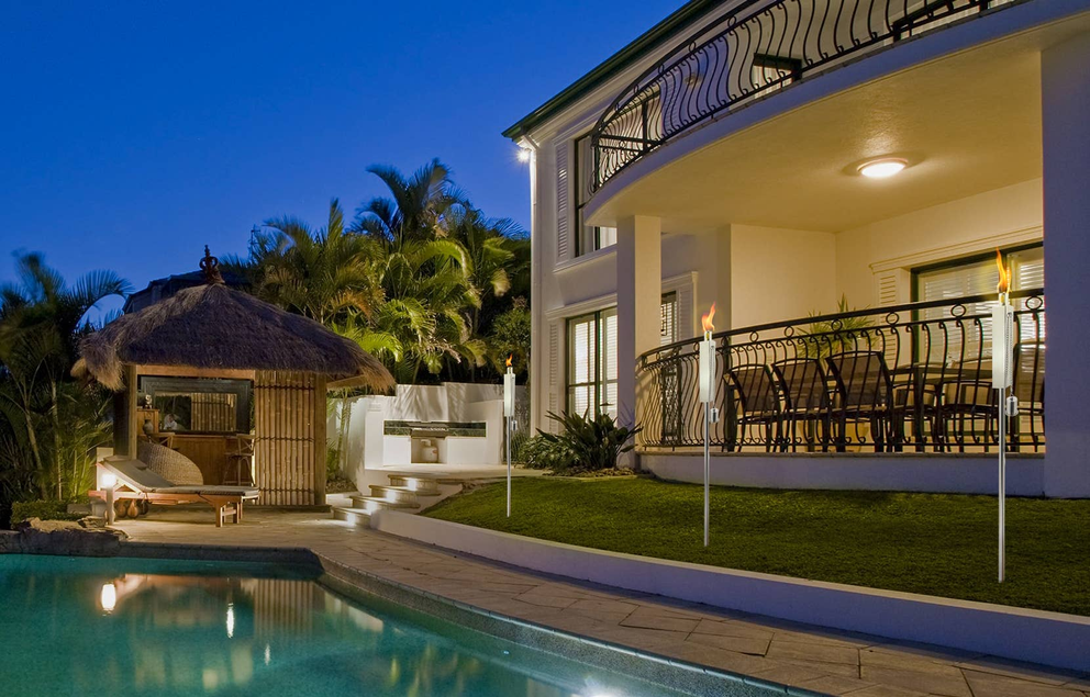 Outdoor polished stainless rectangular torch with visible flame beside patio