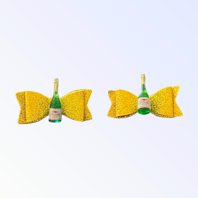 Pair of yellow glitter dog hair bows with small green bottle ornament