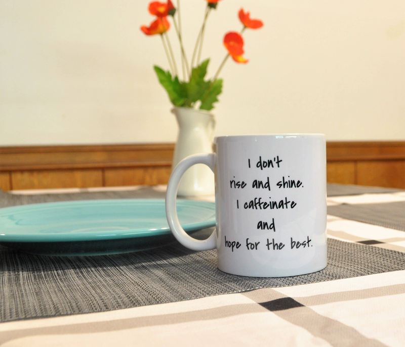 White coffee mug with black quote: 'I caffeinate and hope for the best'