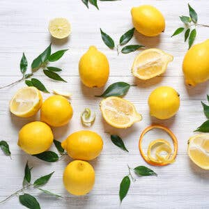 Lemon white balsamic vinegar with scattered lemons and lemon wedges