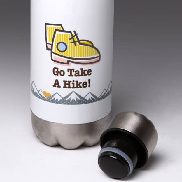 White water bottle with yellow hiking shoe graphic, silver base, black lid cap nearby.