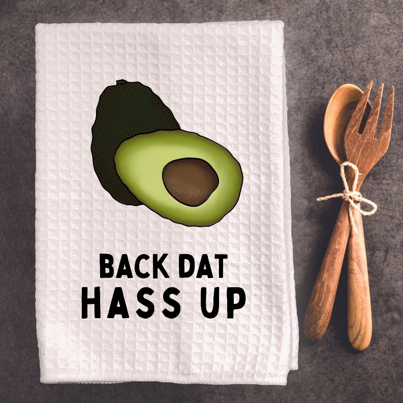 Folded white tea towel with avocado icon and “BACK DAT HASS UP” lettering