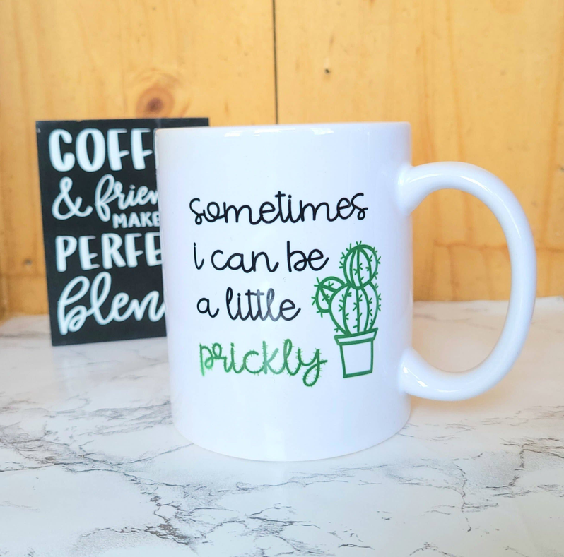 White ceramic coffee mug with green cactus quote and light blue handle