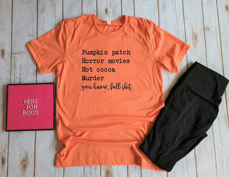 Orange crewneck T-shirt with Halloween-style text graphic