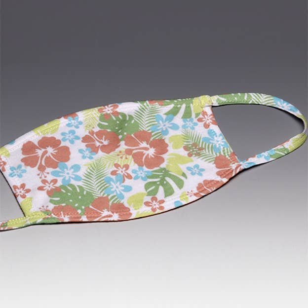 Tropical face mask with colorful floral and leaf print, curved shape and ear loop