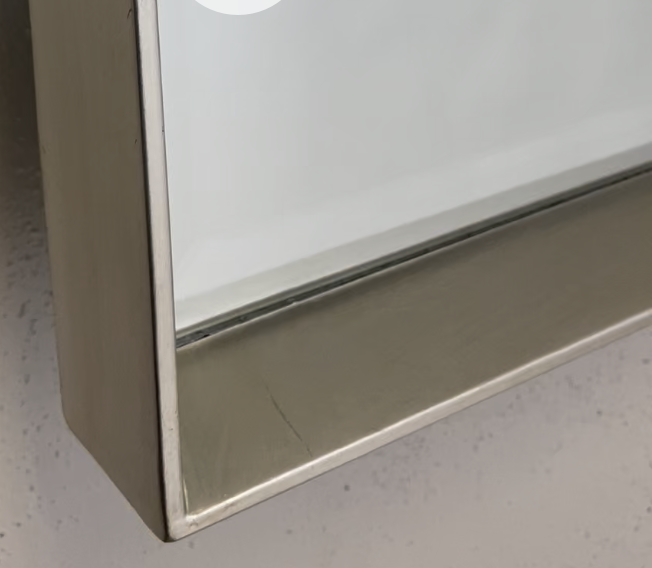 Close-up of brushed silver tray mirror frame edge with beveled glass
