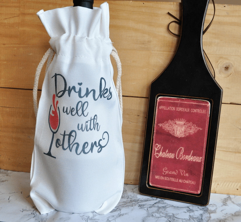 White fabric wine bag with drawstring and Drinks well with others print