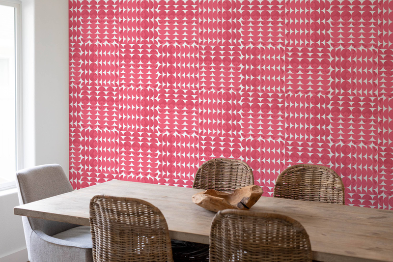 Peel-and-stick wallpaper panel on accent wall with red and pink circle and scallop print