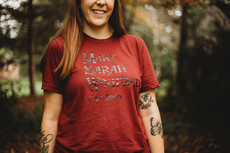 Red crewneck T-shirt with “Mary Sarah Winifred” front graphic, short sleeves worn