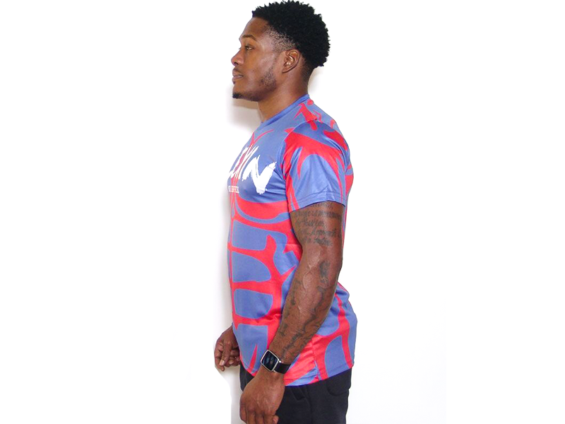Red and blue patterned crew-neck t-shirt with sleeve logo, side profile.