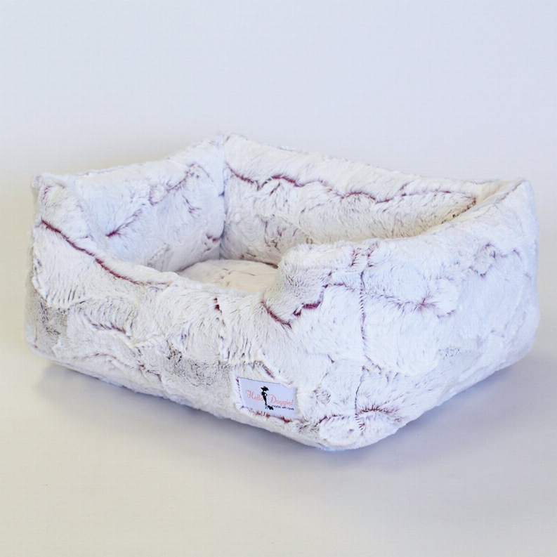 Rectangular plush dog bed with raised sides, light blue fabric, stitched details