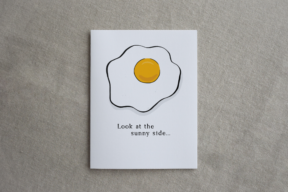 White rectangular card with sunny-side egg illustration, yellow yolk in black outline