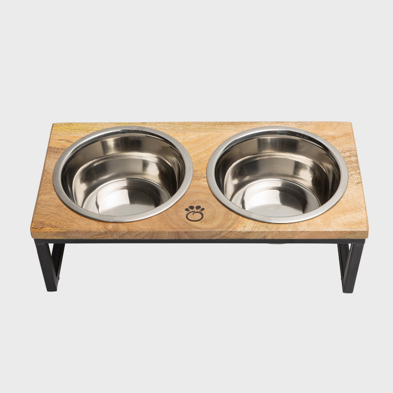 Elevated pet feeder with two stainless steel bowls on wood top and black legs