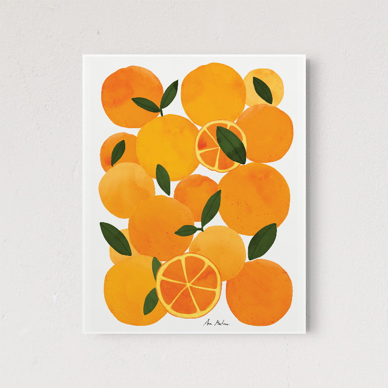 Orange citrus wall art print with green leaves in a white border frame