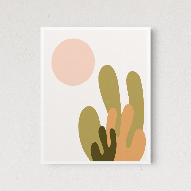 Framed desert cactus wall art featuring a large pink sun and stacked green tan cacti