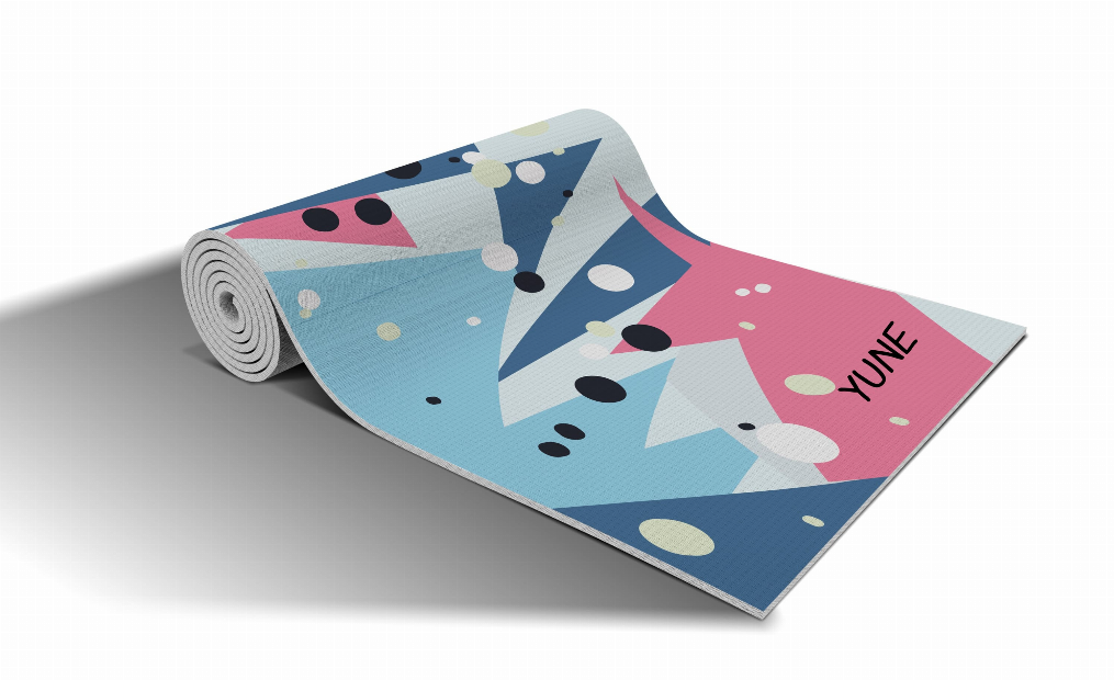Rolled abstract yoga mat in blue, pink, and orange with geometric shapes and dots